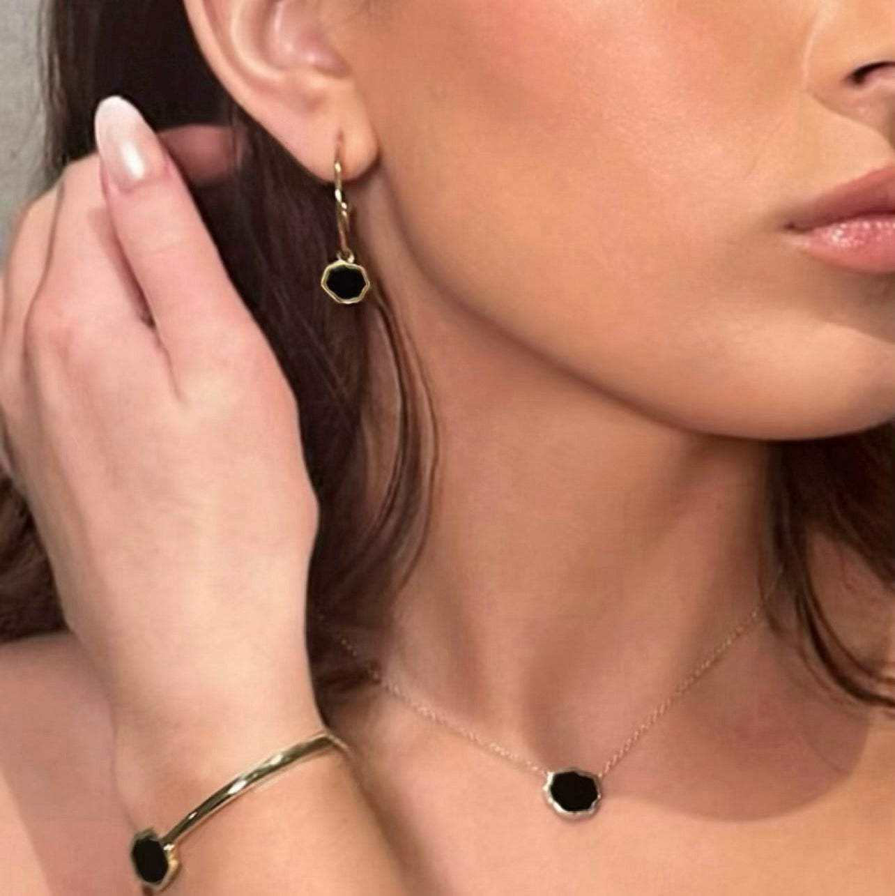 Female wearing black onyx necklace, bracelet, and earrings